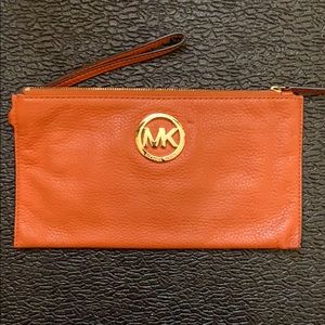Burnt orange Michael Kors wristlet.